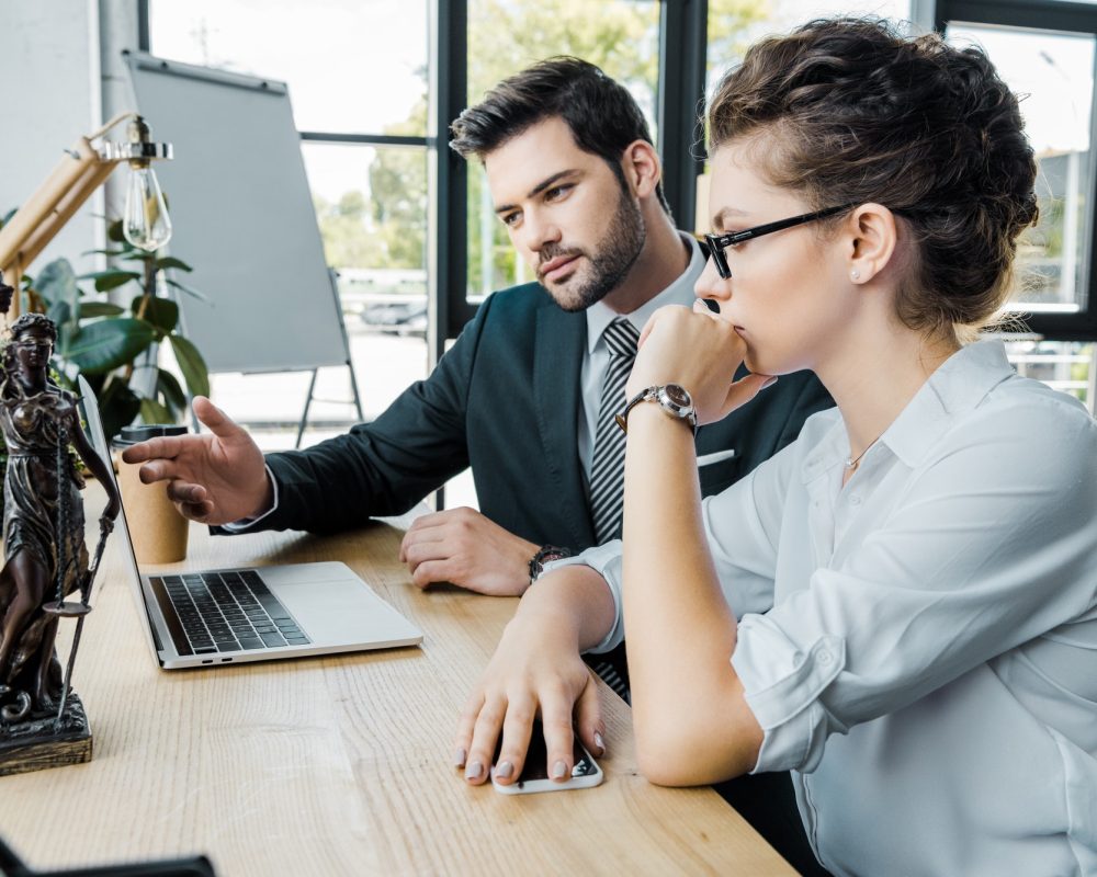 lawyers-discussing-work-at-workplace-with-laptop-and-femida-in-office.jpg